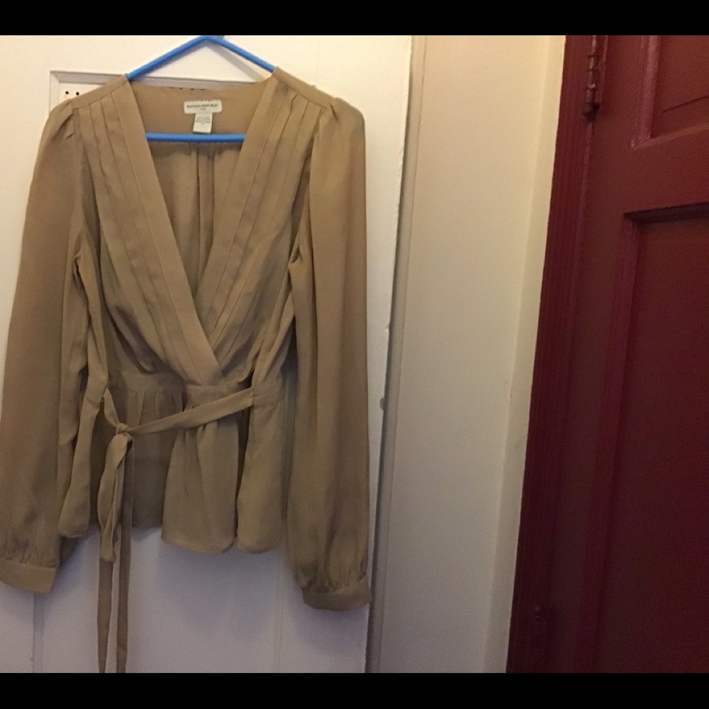 Beige blouse front half way.  With a front belt.  Made in China.  100% Polyester